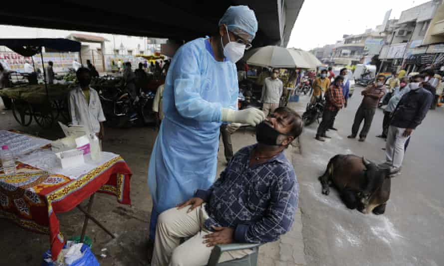 A health worker takes a nasal swab sample to test for COVID-19 in Ahmedabad, India on Friday