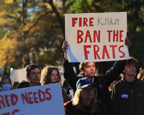 a person holds a sign that reads 'fire Kotlikoff ban the frats'