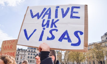 A protester holds a ‘Waive UK Visas’ sign in Trafalgar Square