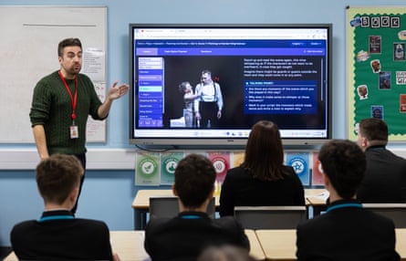 Paul Ainsworth instructs a classroom of schoolchildren in front of a large TV screen