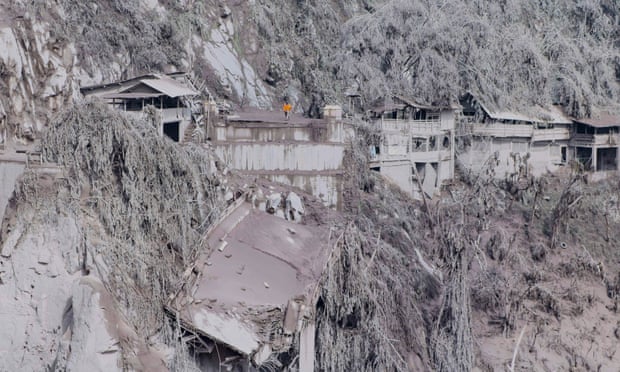 Ash covers houses and trees on the slopes of Mount Semeru the day after Saturday’s eruption