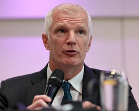 Al Carns speaking into a microphone at a media event