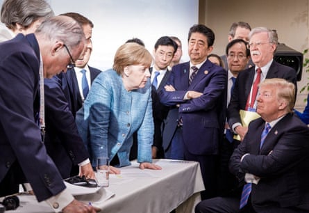 Donald Trump (R) talking with Angela Merkel and surrounded by other G7 leaders during a meeting in Quebec, Canada, in June 2018.