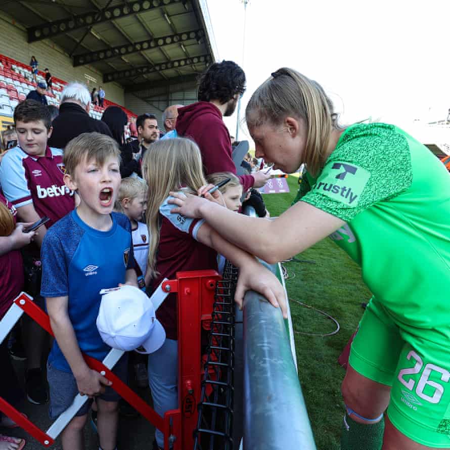 West Ham fans wait for West Ham players after the game as goalkeeper Emily Moore signs a shirt.
