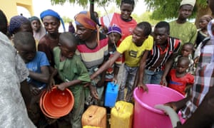 People collect water at a camp for displaced people in Geidam, in Nigeria’s Yobe state.