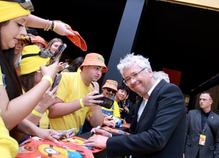 Pierre Coffin greets fans who are dressed in yellow T-shirts and orange bucket hats before the Minions & Monsters premiere in Los Angeles