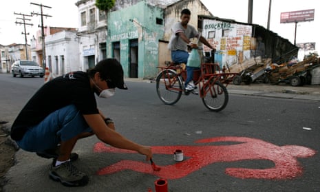 An activist paints the silhouette of a murder victim at the Coque slum in Recife, Brazil. The report’s authors fear voters may look to strongman-style populists to solve the crisis.