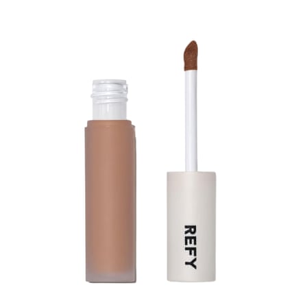 A bottle of Refy Concealer with the application wand standing separately. The wand is attached to the lid.