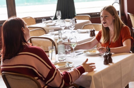 Emma and Alys chat across a restaurant table