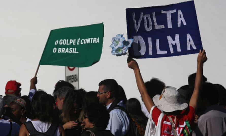 Rousseff supporters on the streets of Brasília hold signs in Portuguese reading ‘Come Back Dilma’ and ‘The coup against Brazil’.