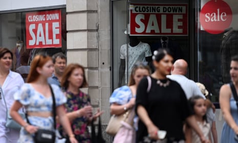 A picture of pedestrians passing a closing down sale at a store in central London, on 4 August 2022.