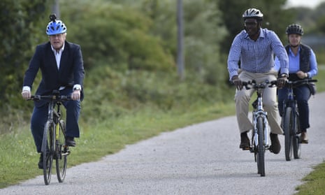 Boris Johnson with two others cycling along