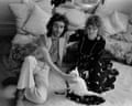 Ossie Clark and Celia Birtwell sit on a cushioned floor, he petting a white cat