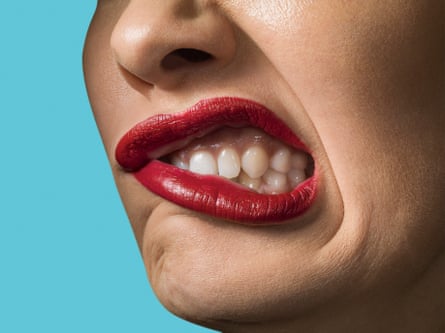 A woman with red lipstick, grimacing