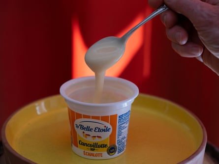 A pot of cancoillotte with a spoon scooping out some of the cheese
