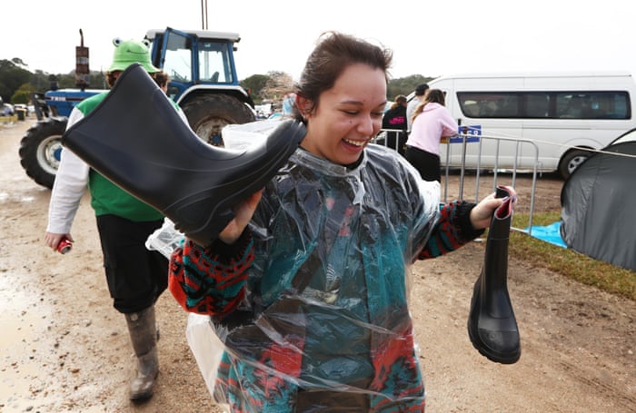 A festival-goer carries their gumboots through the mud at Splendour in the Grass near Byron Bay on Saturday.