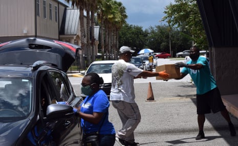 Volunteers distribute boxes of food from the Second Harvest Food Bank of Central Florida during a drive-through event at City of Destiny church on 6 July, 2020. The demand for food continues in the Orlando, Florida area due to the large numbers of service workers and others who have become unemployed due to the coronavirus pandemic.