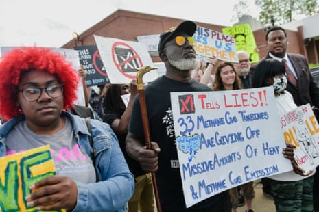 A crowd of people gather and hold anti-datacenter signs.
