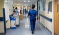 Nurse wearing scrubs walking in a hospital ward