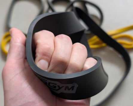 Hand holding the thickest Technogym power band with two others in the background