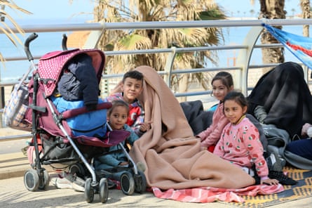 Displaced children who fled Israeli airstrikes sit at the corniche waterfront in Beirut.