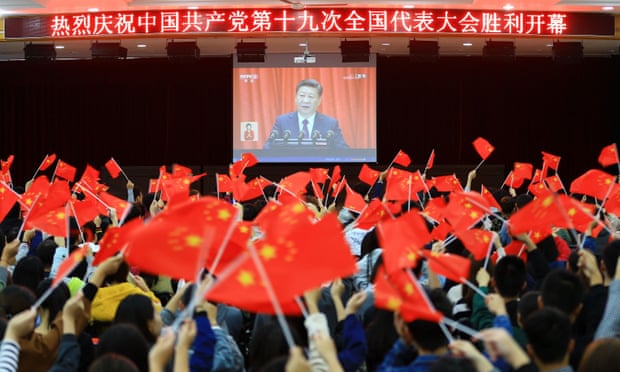 College students wave national flags as they watch the opening of the 19th Communist party congress in Huaibei in China’s eastern Anhui province.
