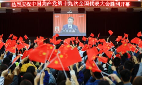 College students wave national flags as they watch Xi Jinping speak at the opening of the 19th Communist party congress in Huaibei, in China’s eastern Anhui province.