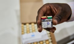 Two vials of Mosquirix in an African man's hand at a depot in Kisumu, Kenya