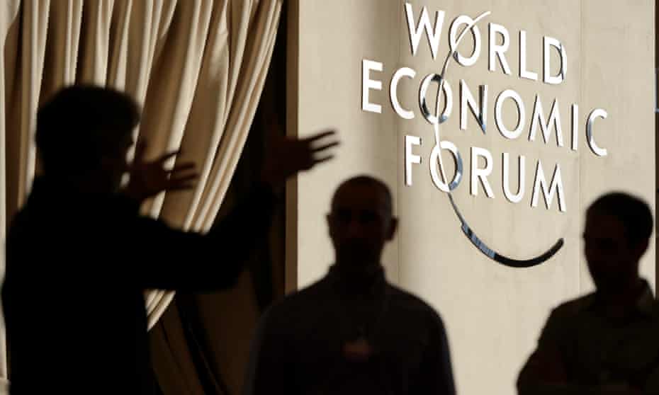 People discuss in front of a WEF logo inside the Congress Center, two days before the opening of the 46th Annual Meeting of the World Economic Forum, WEF, in Davos