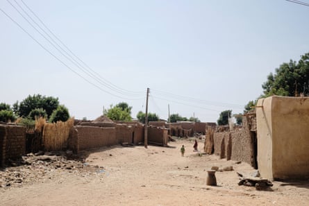 Two figures on a sandy road between stone walls