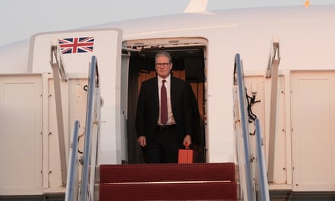 Keir Starmer exits an official UK aircraft onto waiting red steps