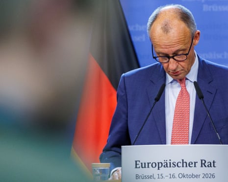 Chancellor Friedrich Merz looks down while speaking at a European Council podium