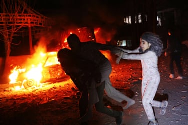 People running past a burning car