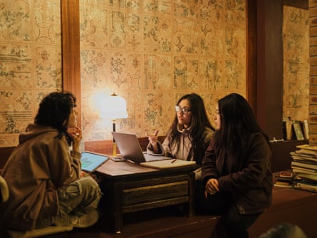 Melak Al-Zuhairi, Raiha Mariam and Renin Hamdan seated at a table with a lamb