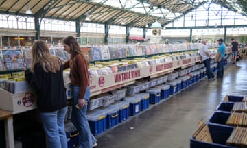 Two young women or teenagers looking through vinyl records at a large records fair