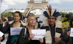 Ladio Veron (C), a leader of  indigenous Guarani Kaiowá tribe, stands in front of the Eiffel tower in Paris on 20 May during his tour to ask for help to fight against the agribusiness that threatens their population in the mato Grosso do Sul, Brazil