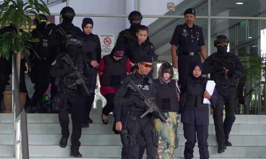 Doan Thi Huong and Siti Aisyah being escorted out of a courthouse by armed guards.