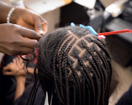 Hair stylist braiding hair.