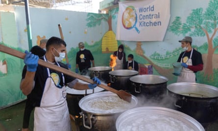 People making food in large containers.