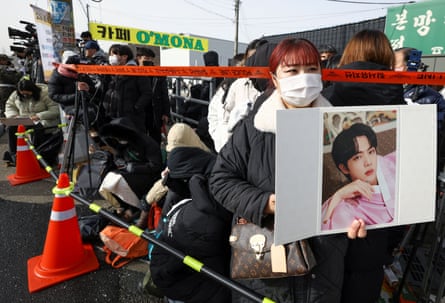 Fans wait outside a South Korean army camp where BTS member Jin begins military service.