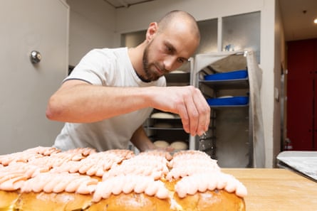 Julian Pinto adds the finishing touches to a batch of buns