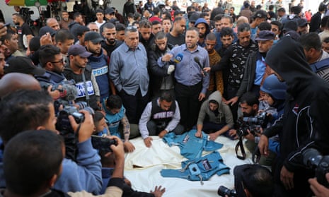 Journalists, relatives and friends pray over the bodies journalists Sary Mansour and Hassouna Sleem.