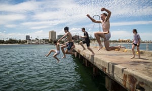 People jump off St Kilda Pier in Melbourne as the city swelters on Monday