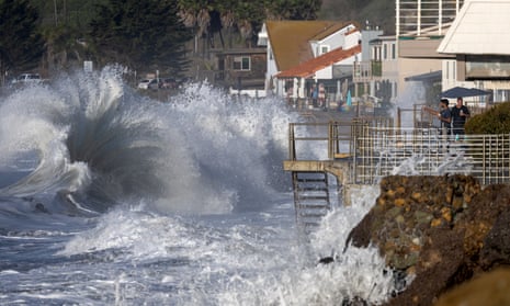 Men watch from a balcony on Faria beach as huge waves crash on the shore on Thursday in Ventura, California.