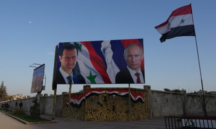 Assad and Putin watch over from billboards between the east and west of the city.
