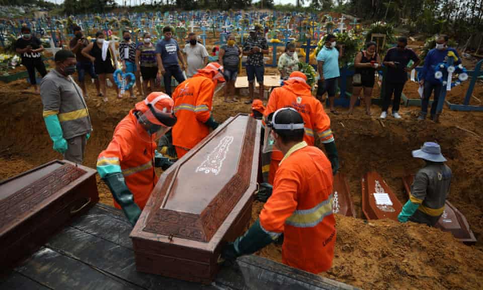 Gravediggers carry a coffin during a collective burial of people who have died due to Covid-19, at the Parque Tarumã cemetery in Manaus on Tuesday.