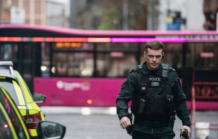 Tommy Foster (Nathan Braniff) with a pink bus in the background in Blue Lights.