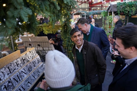 Sunak smiling while looking at a stall