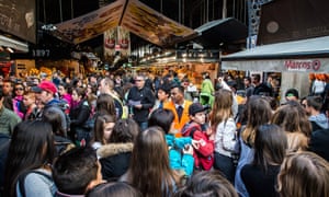 A security staff member controls access to ‘La Boqueria’, Barcelona’s most popular market. Large tourist groups are now banned.