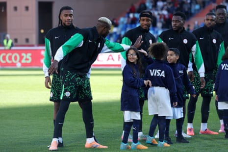 Nigeria's Victor Osimhen high-fives a mascot before the match.